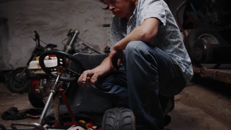 cinematic shot of mechanic inspecting a chain lock standing in front of his go-kart