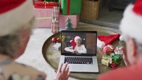 Senior-caucasian-couple-using-laptop-for-christmas-video-call-with-happy-woman-on-screen