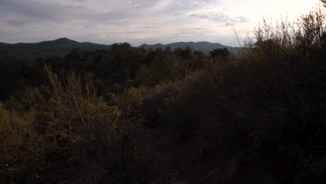 Vista-Inclinada-De-La-Puesta-De-Sol-Proyectando-Sombras-En-La-Cima-De-Una-Montaña