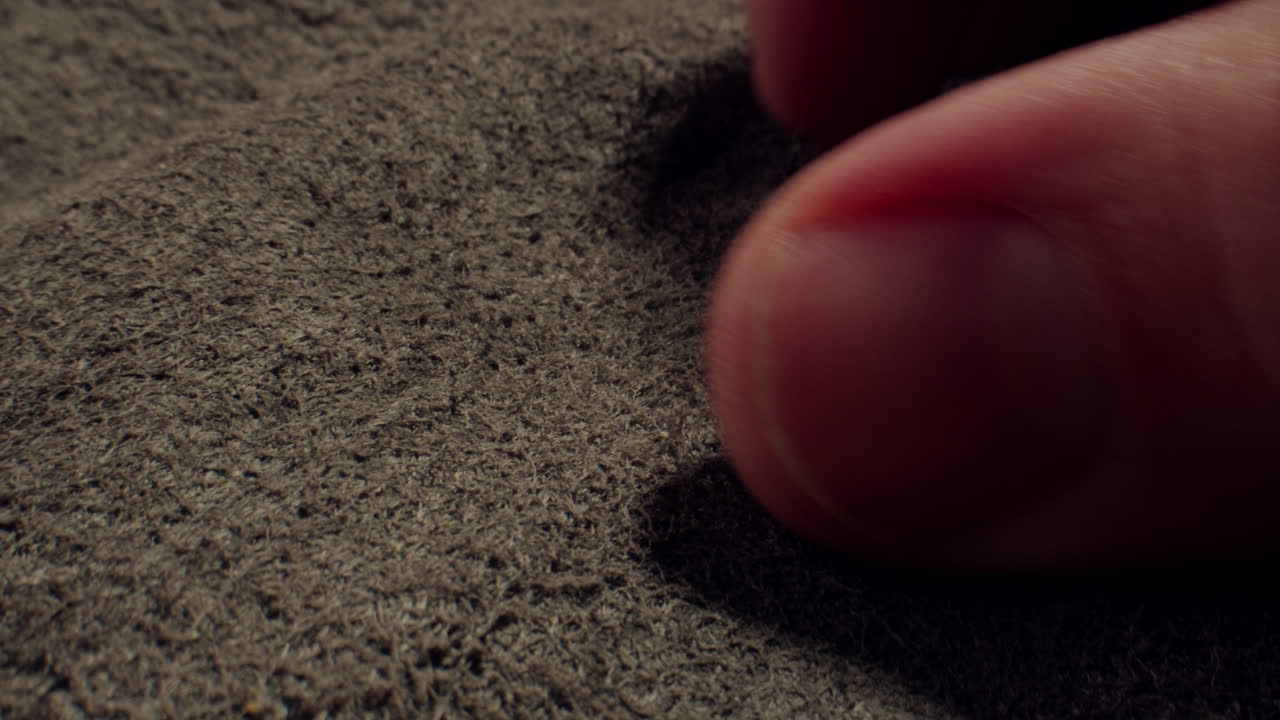 Human Finger Gently Touching and Feeling Suede Fabric Texture