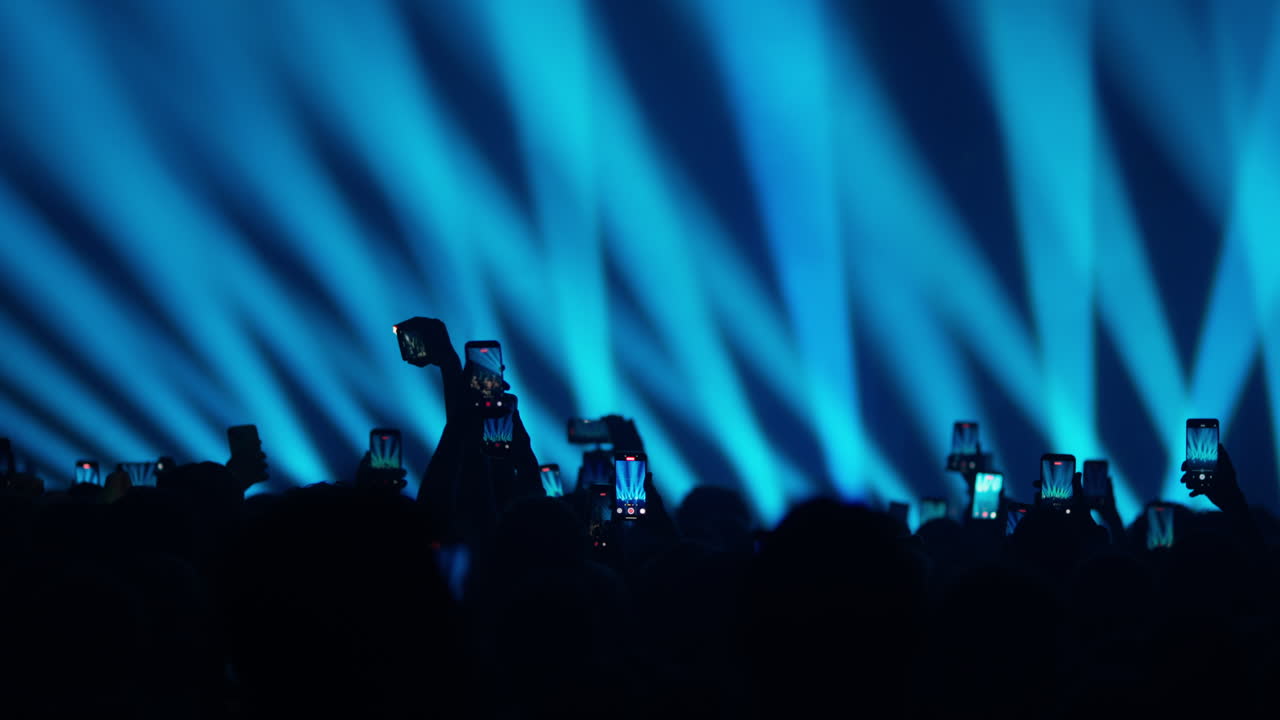 Silhouette del pubblico sotto luci blu del palco