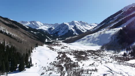 bluebird sunny day spring winter colorado beautiful mountain views and peaceful stream ashcroft maroon bells aspen colorado iconic scenery aerial up motion