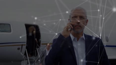 Animation-of-network-of-connections-over-businessmen-using-smartphone-at-the-airport