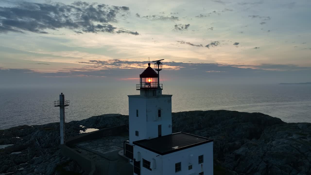 faro de marsteinen en la costa noruega, con el sol iluminando a través del vidrio del faro, aérea