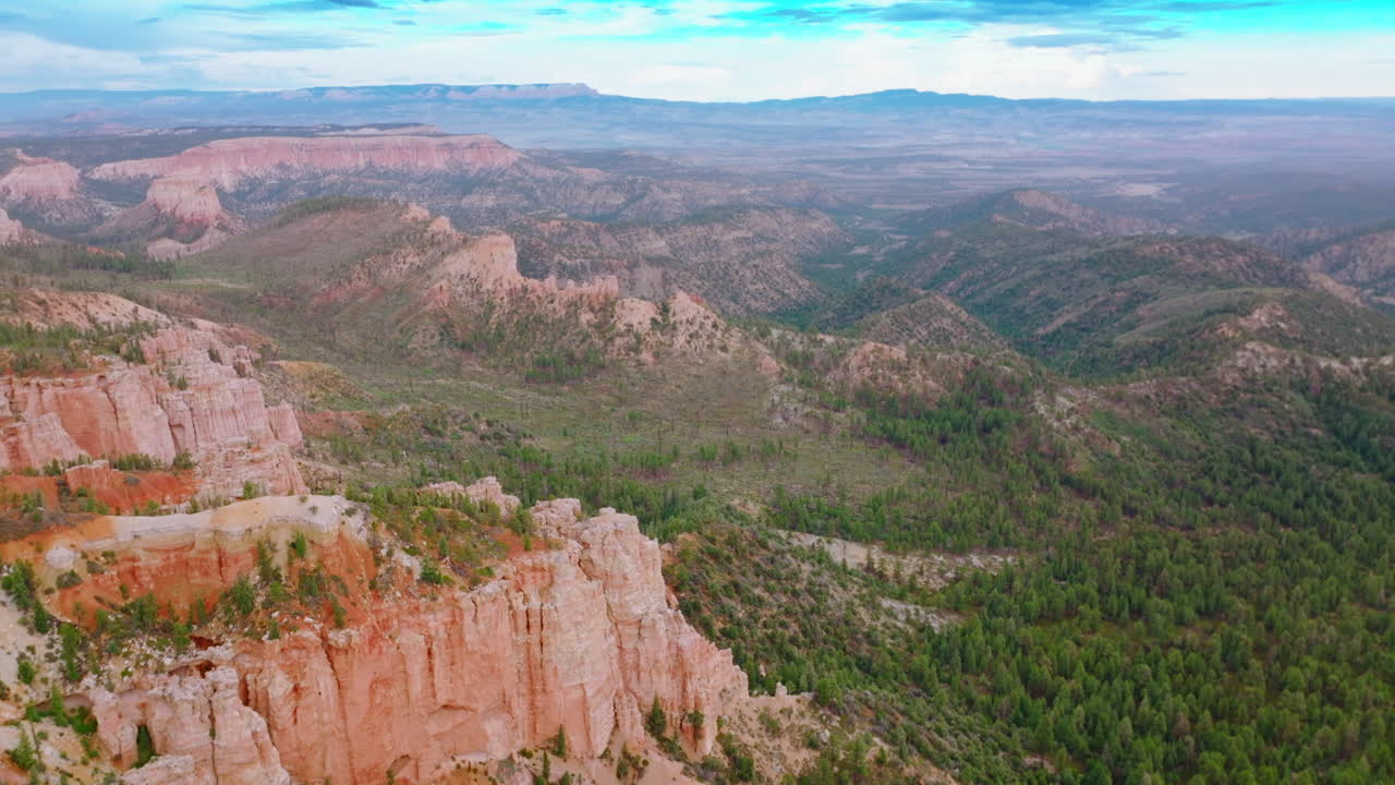 Panning view of the beautiful rocks in Utah, USA. Pine tree forest covering the landscape at the backdrop of blue sky.