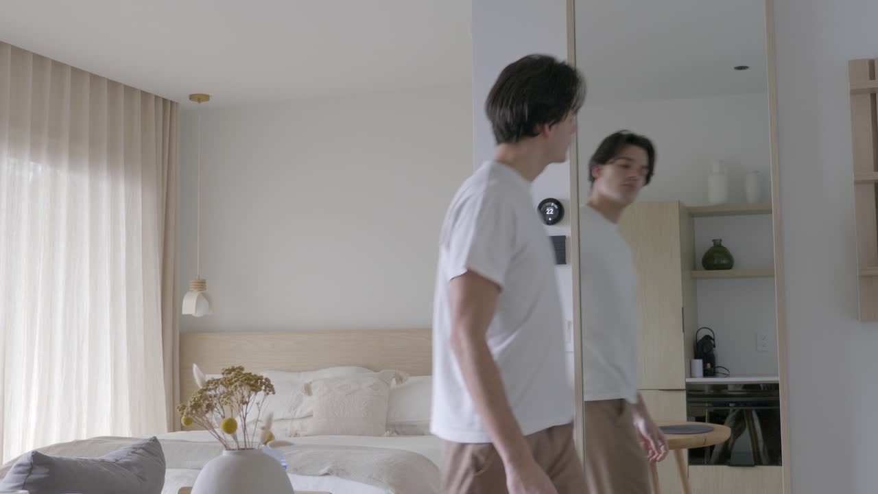 백인 남자가 온도 조절기 쪽으로 걸어가서 온도를 올립니다.