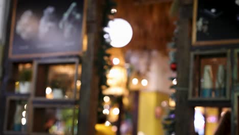 una secuencia que captura una vista borrosa del interior de un restaurante, destacando la iluminación cálida y los elementos decorativos