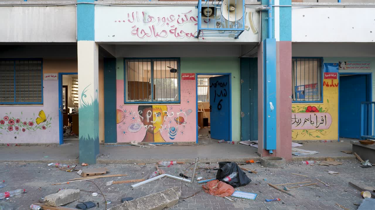 Muovendosi con cautela attraverso detriti sparsi verso un'aula palestinese colorata