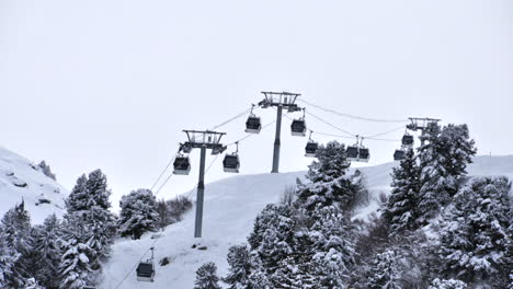 Zeitraffer-Einer-Skiliftblase,-Die-über-Einen-Mit-Bäumen-Bedeckten,-Schneebedeckten-Berg-Fährt