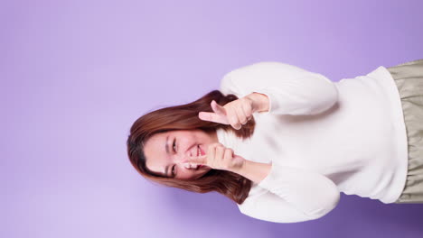 mujer asiática alegre y divirtiéndose señalando con el dedo a la cámara
