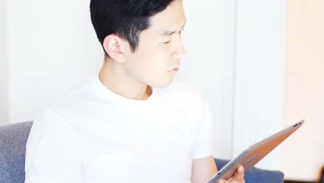 디지털 태블릿과 휴대폰을 사용하는 남자가 거실 4k