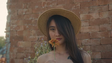 woman with straw hat and flower
