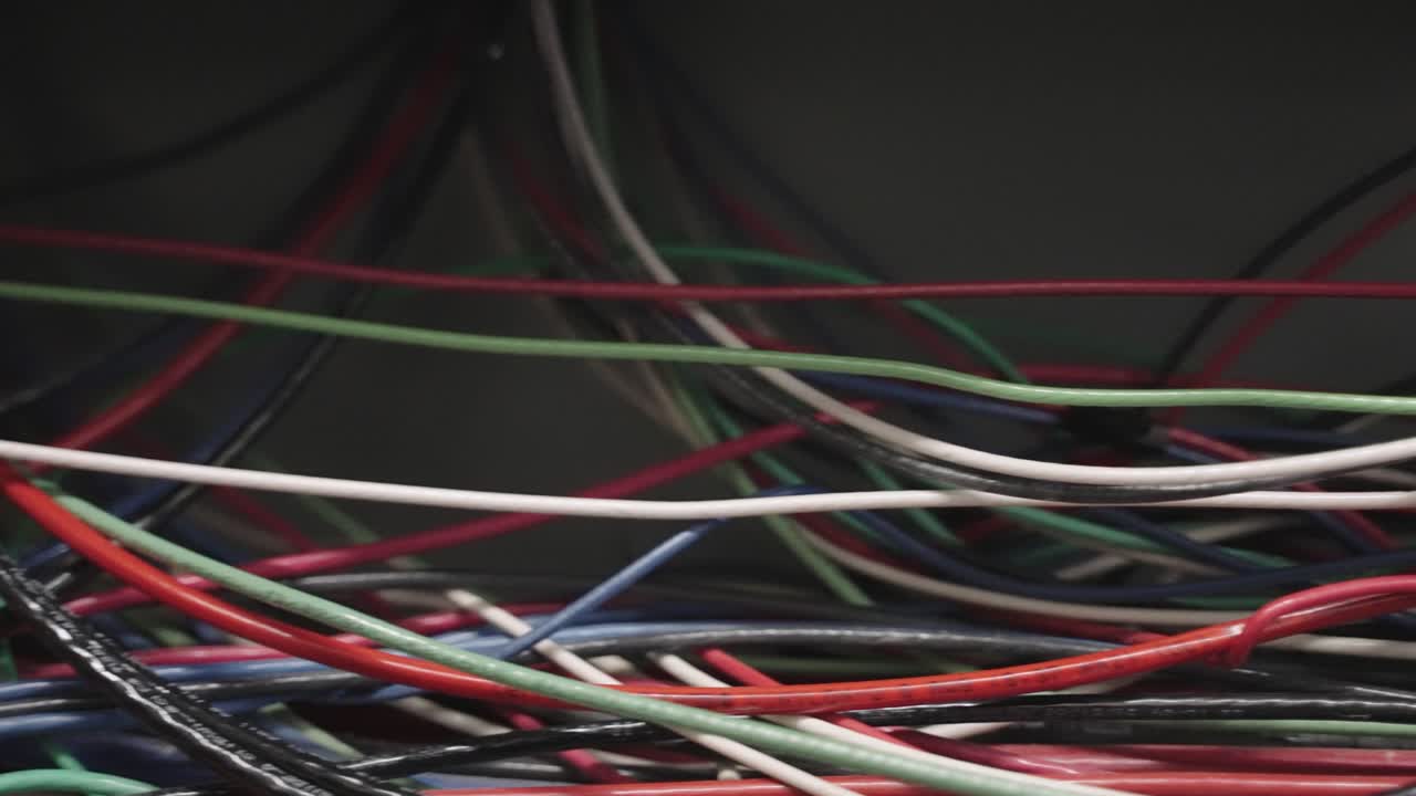 Panning close up of messy multi colored electrical wires