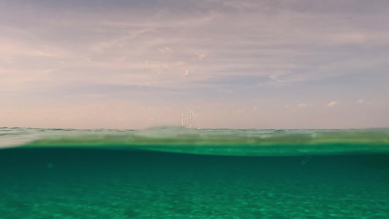 돛을 내리고 수평선에 정박한 범선의 수중 표면 원근법 분할