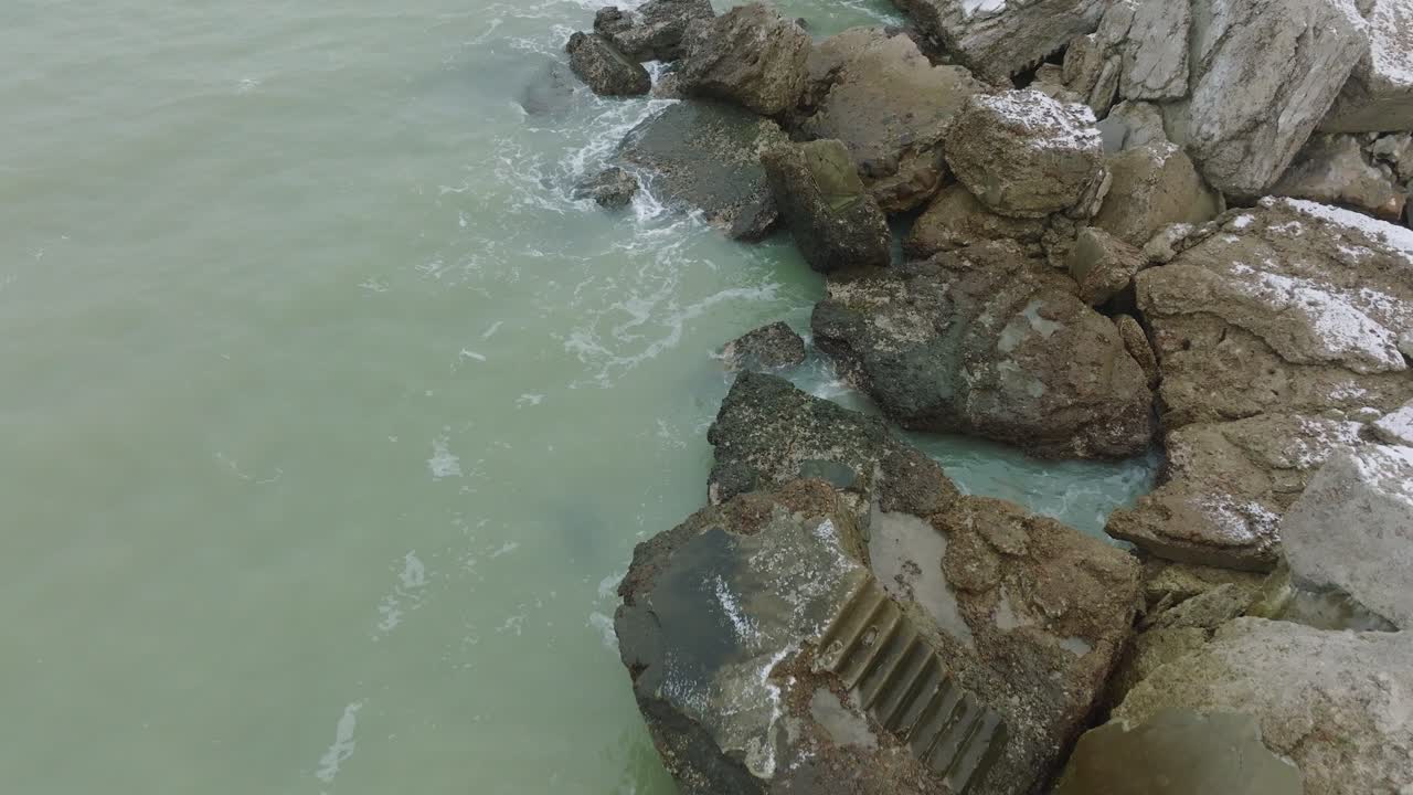 Vue aérienne à vol d'oiseau de bâtiments de fortification côtiers abandonnés aux Forts du Nord de Karosta sur la plage de la mer Baltique, par une journée d'hiver couverte, prise de vue par drone avançant