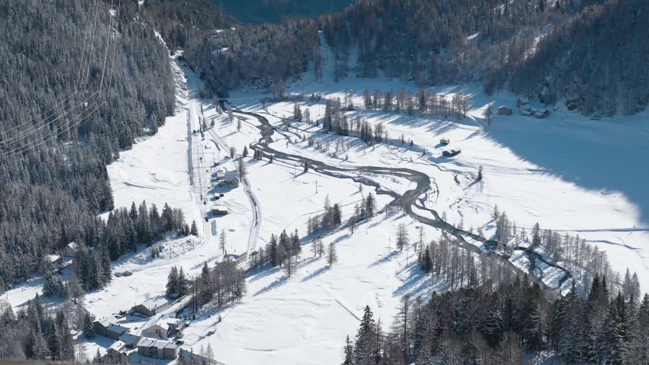vista de un valle cubierto de nieve, río y montañas en un soleado día de invierno desde alp grum, suiza