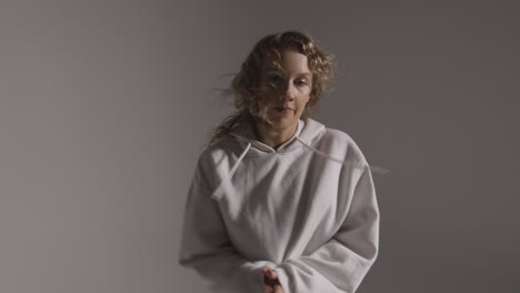 studio shot of young woman having fun dancing against grey background 3