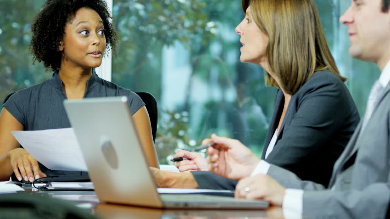 gerente afroamericana en una reunión usando una computadora portátil