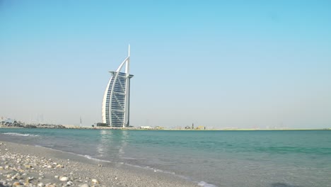 burj al arab as seen from jumeira beach, peaceful windy beach, waves, blue sky, blue ocean etc