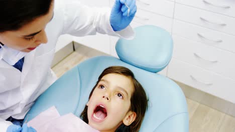 Dentist-examining-a-young-patient-with-tools