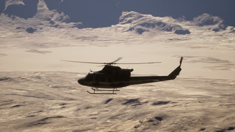 helicopter flying over snowy mountains