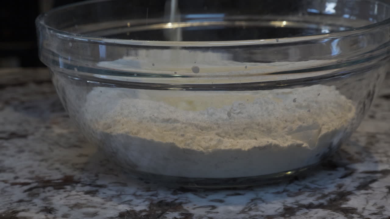 믹싱볼에 밀가루 위에 우유를 붓는 모습