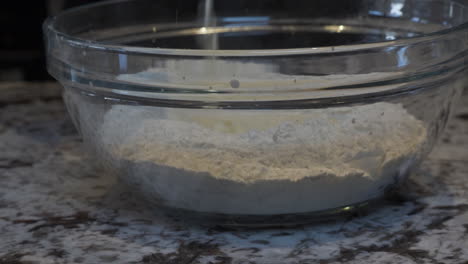 milk being poured on top of flour in mixing bowl