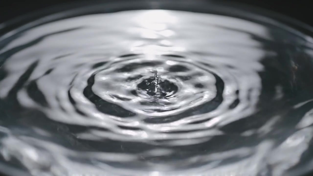 Makroaufnahme von sich ausbreitenden Wasserwellen in einer weißen Schale