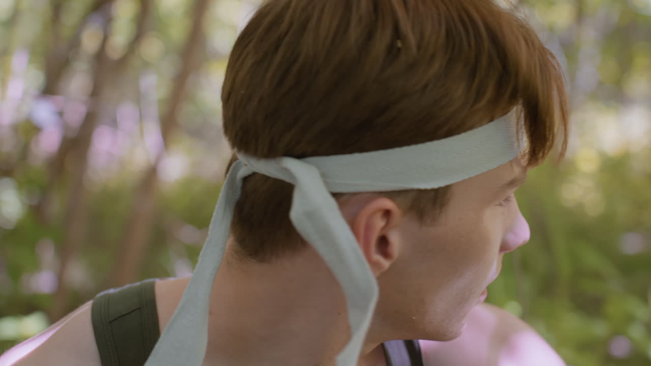Side view of tourist tightening headband with focus on facial expression, still on what action to take in a vibrant forest, while showing dedication and readiness for next phase of journey