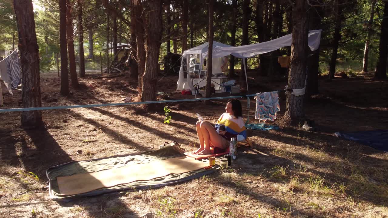 숲 속의 젊은 여성, 일몰 때 책을 읽고 앉아 있습니다.