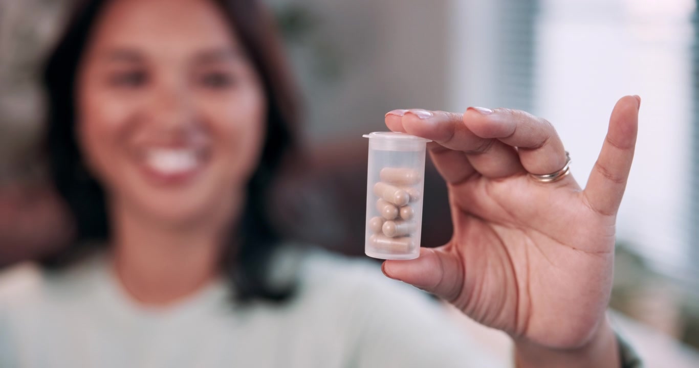 Donna che Tiene in Mano un Piccolo Contenitore di Capsule