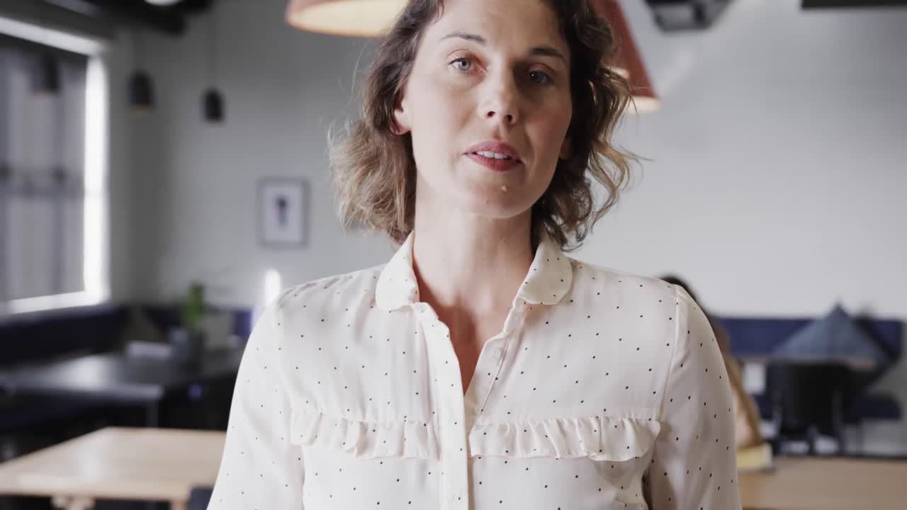 Ritratto di felice donna d'affari caucasica in abiti casual che usa un tablet in ufficio, al rallentatore