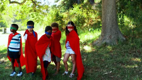 friends pretending to be a superhero in park