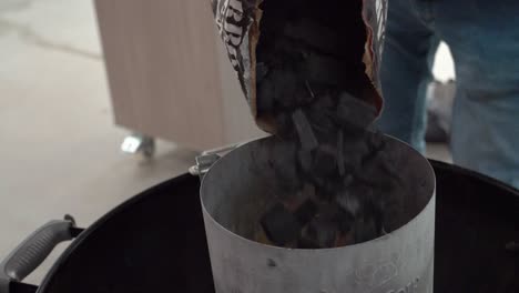 black coals are added to charcoal grill, slow motion