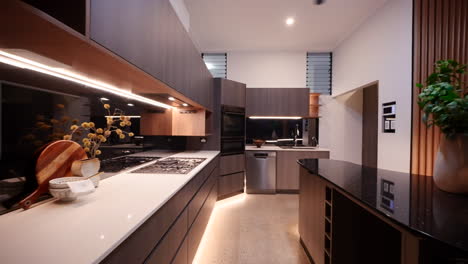 luxurious dark wood kitchen with gas stove strip lighting, and walk in pantry