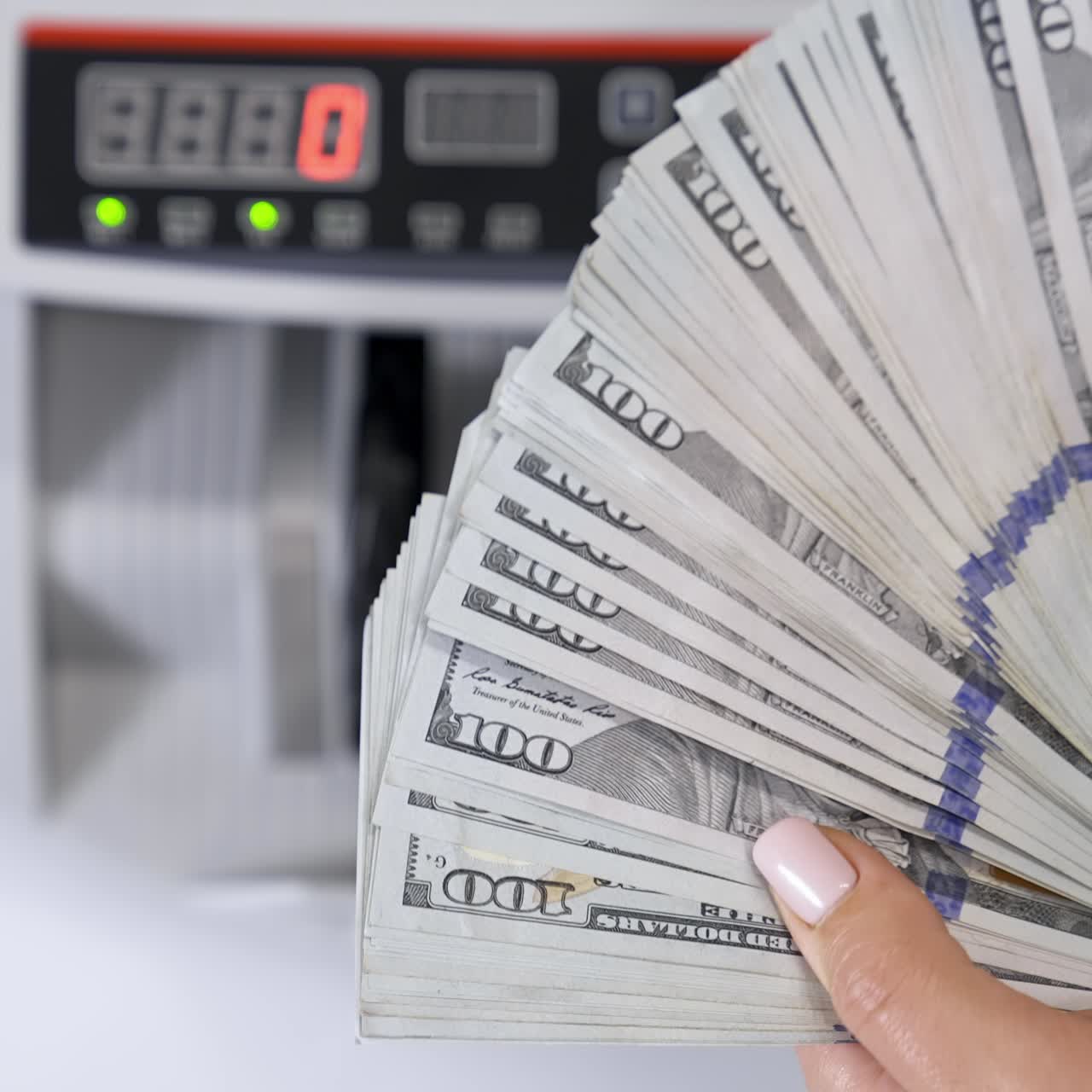 Hundred dollar bills in female's hands. Much american paper money in hands on the background of electronic calculating machine. Close-up