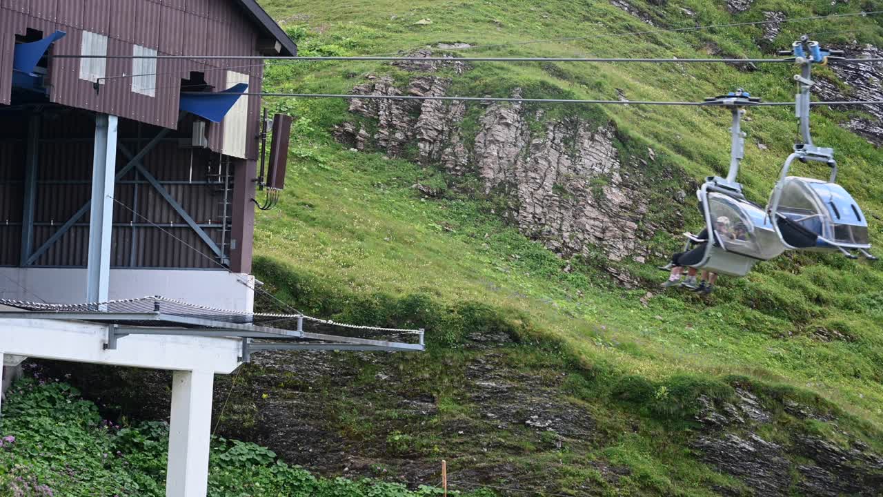edificio de llegada de góndola en los alpes suizos, transporte, instalaciones para excursionistas y ciclistas, ladera empinada de la montaña detrás, obwalden