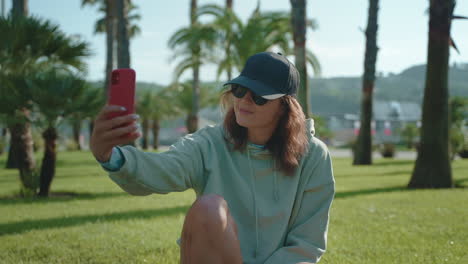 una mujer tomando una selfie en un parque.