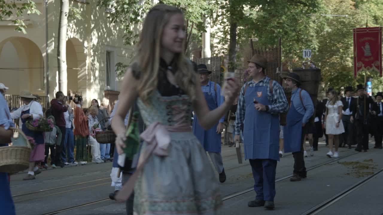 Slow motion shot of a Winemakers Share Wine in a Parade Celebration while marching, at the Cannstatter Volksfest Historical Parade, in Stuttgart Bad Cannstatt, Baden-Württemberg, in Germany