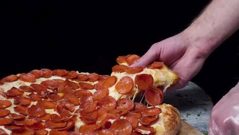 la mano tirando de una rebanada de pizza de pepperoni