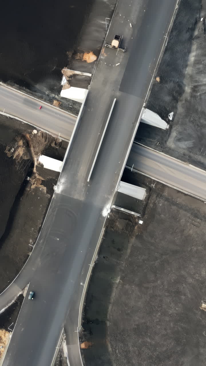 Aerial View of Highway Construction Site with Overpass and Unfinished Roundabout
