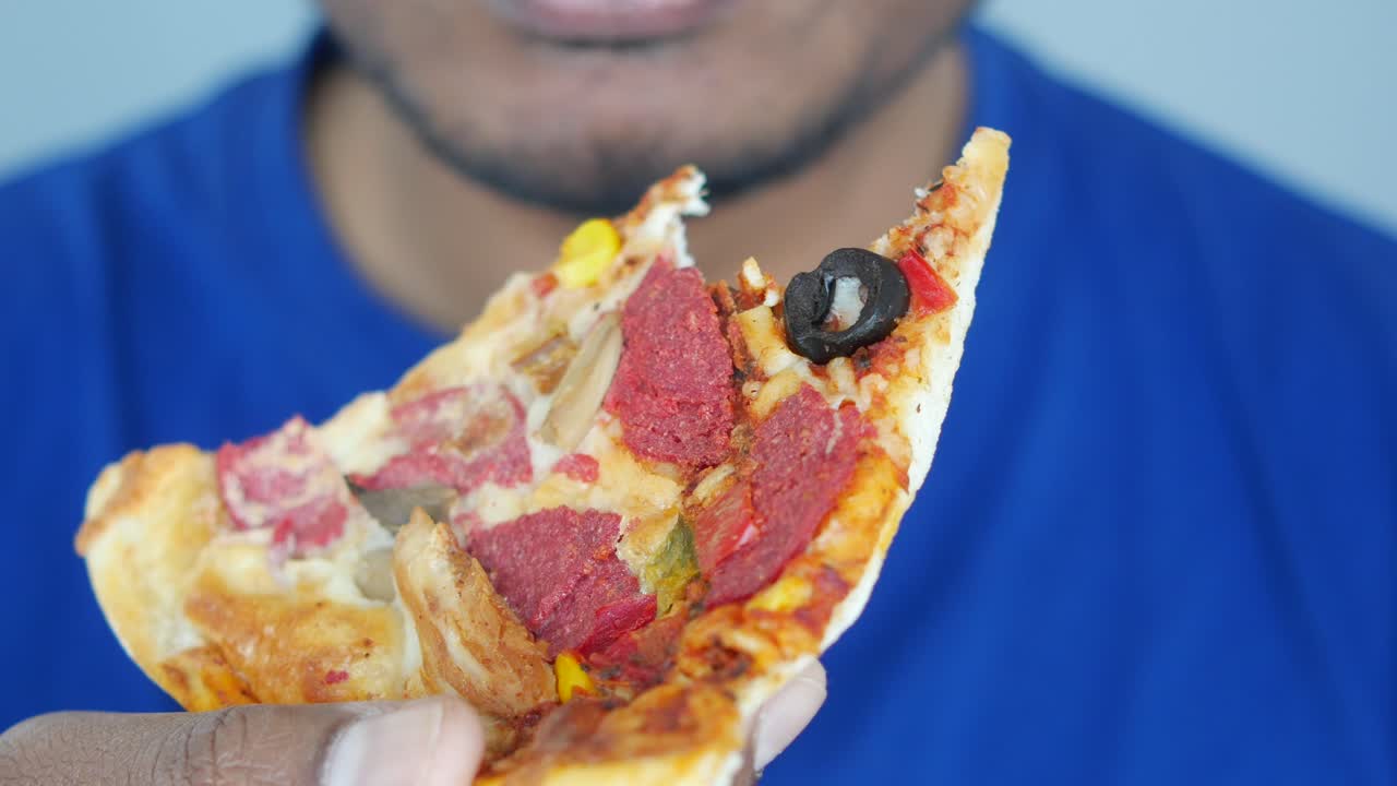 피자 한 조각을 먹는 사람