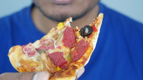 una persona comiendo una rebanada de pizza
