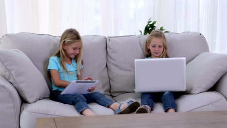 sisters using laptop and tablet pc