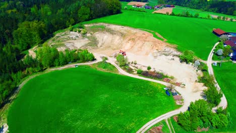vista aérea del sitio de la cantera en un paisaje agrícola verde con maquinaria pesada