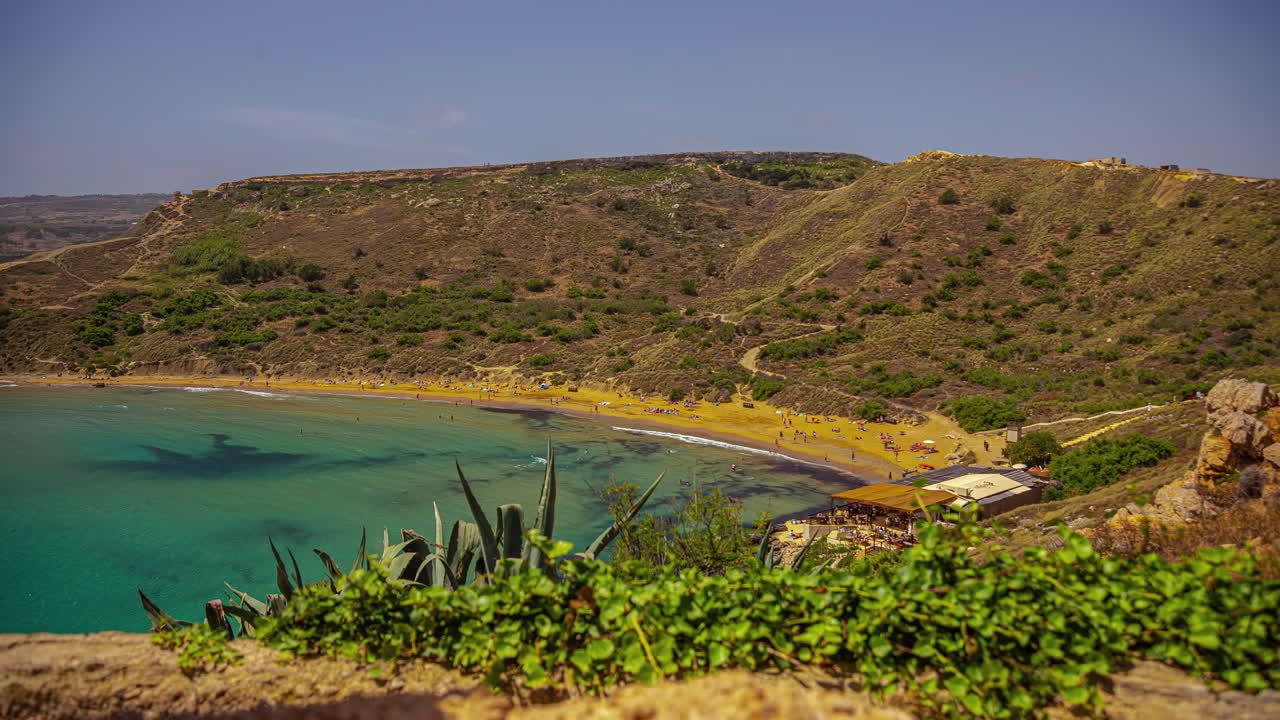 disparo de ángulo alto sobre los turistas disfrutando a lo largo de la playa de arena en un día soleado en el lapso de tiempo