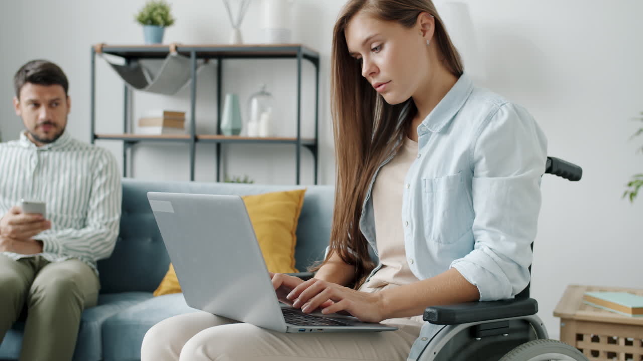 mujer en silla de ruedas trabajando en una computadora portátil
