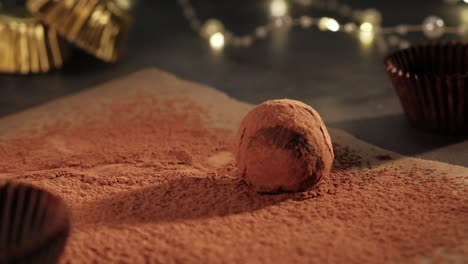 slowmotion chocolate truffles rolling in cocoa powder