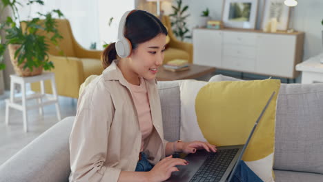 woman using laptop and headphones in living room