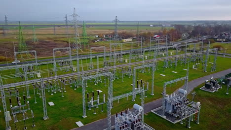 vuelo de drones sobre una planta de energía con todos los cables de alto voltaje que salen en postes altos